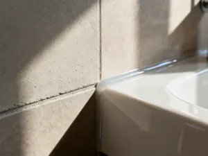Porównanie faktur płytek ceramicznych i drewnianych desek tarasowych na słonecznym balkonie.