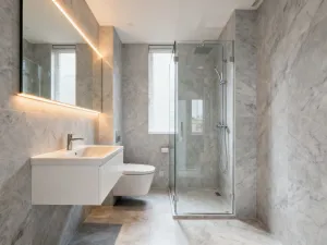 Elegancka łazienka z marmurowymi płytkami, minimalistyczną złotą armaturą i nastrojowym oświetleniem w stylu spa.
